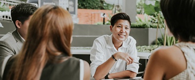 Grupo de empleados sentados a una mesa. 