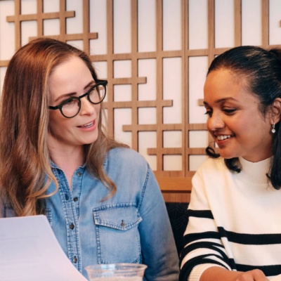 Two women smiling while looking at files