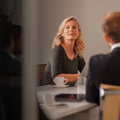 Several people sit around an office table during a board meeting