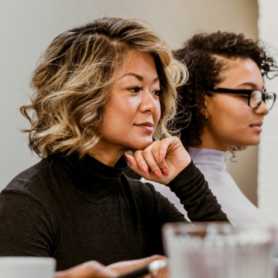 three people seated at a work table with a laptop visible
