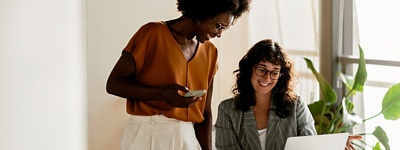 two-women-looking-at-laptop-screen-smiling