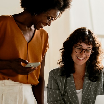 two-women-looking-at-laptop-screen-smiling