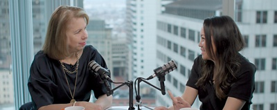 Kathy Pham and Nancy Gibbs sitting at a table together with podcast microphones. 