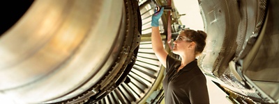 A student engineer working on an aeroplane engine.