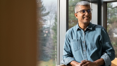Australian executive standing near a window.