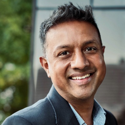 A CFO standing on his office balcony, smiling at the camera.