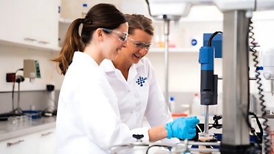 Two professional technicians working in a research lab 16x9