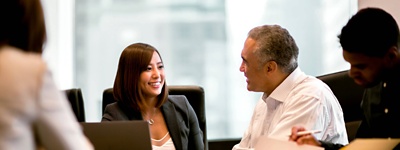 Financial services professionals sitting around an office desk.