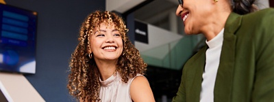 Two people in an office setting, smiling at each other