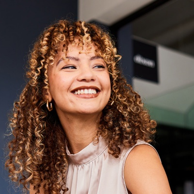 Two people in an office setting, smiling at each other