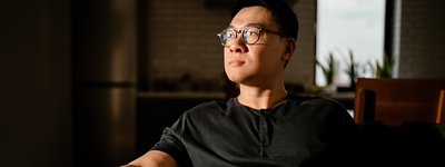 A man in an office looking thoughtfully into the middle distance