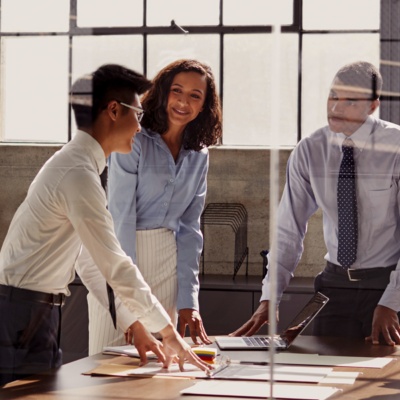 Group of colleagues standing around a table talking