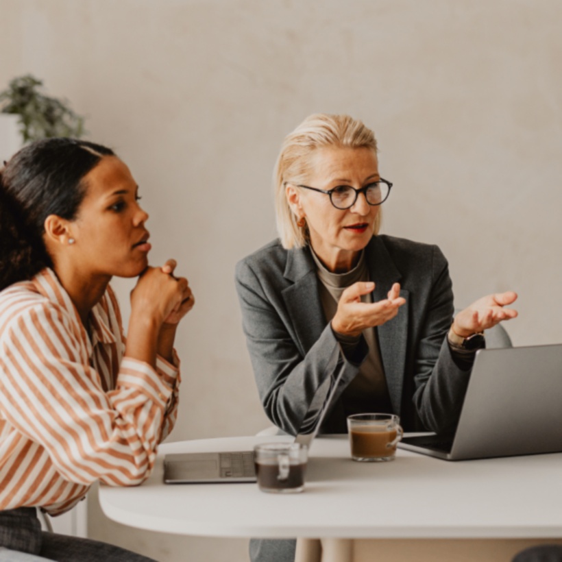 Office workers in a conference room discussing information on a tablet