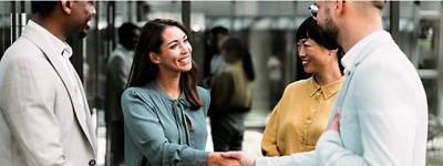 4 人がいて、そのうち 2 人が握手をしている