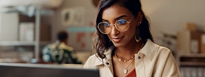 A woman looking at a laptop screen in an office space