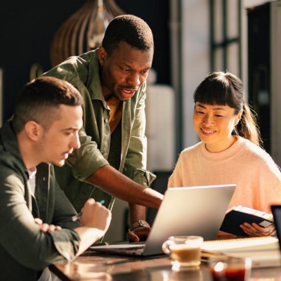 Employees gather around a laptop 