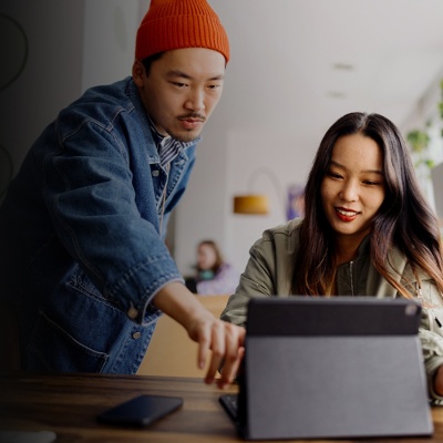 Two people in an office looking at a laptop screen together.