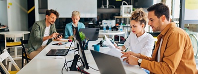 Office workers working in an open concept workspace.