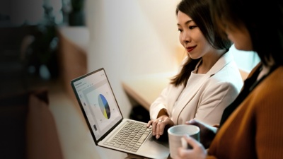Two women look at a business plan on a laptop