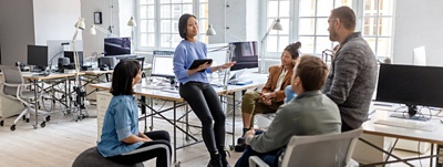 Group of office workers working in an open concept office.