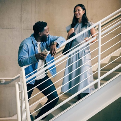 Male and Female colleague chatting on stairs.