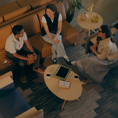 Male and female professionals chatting in lounge area.