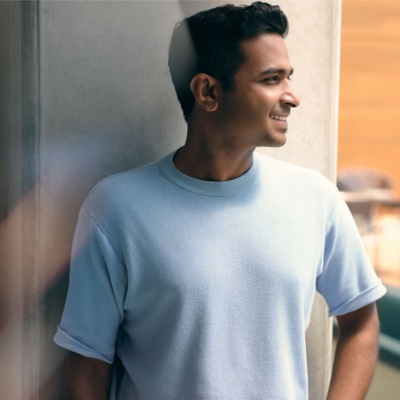 Man smiling standing outside of an office building.