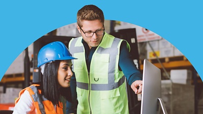 People in construction gear looking at a computer