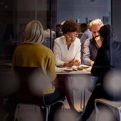 Six colleagues sitting around a table working