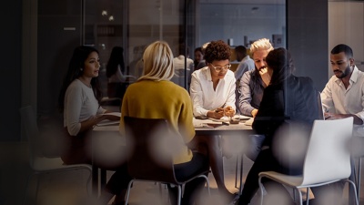 Six colleagues sitting around a table working