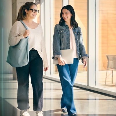 Two women talking in an office hallway about Payroll Configuration.