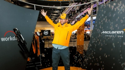 A man wearing an orange jacket with bubbles floating around him