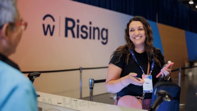 Female attendee smiling at a registration desk