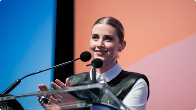 Woman speaker clapping hands at a podium.
