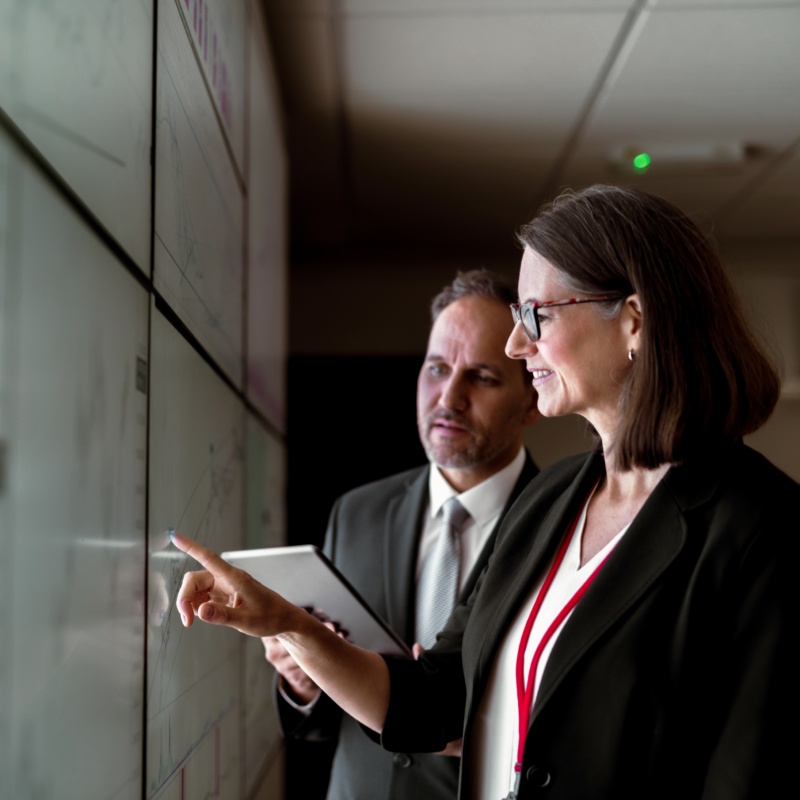 Two business people working on charts and data