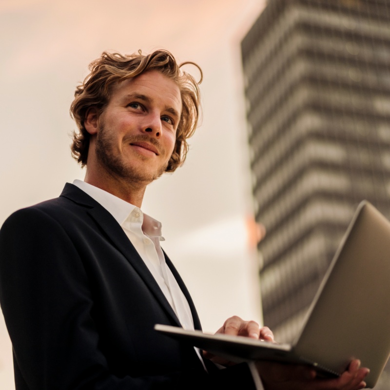 Businessman using laptop with skyscraper background