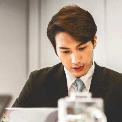 A CFO and CHRO collaborating at an office desk with a laptop.