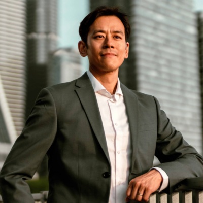 Man standing on bridge in front of city skyline.