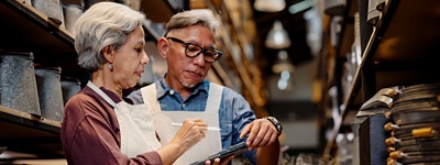 Man and woman using a tablet to check orders.