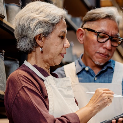 Man and woman using a tablet to check orders.