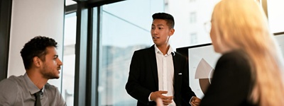 Three colleagues talking and looking at a large computer screen
