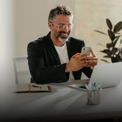 Man smiling looking at phone in office
