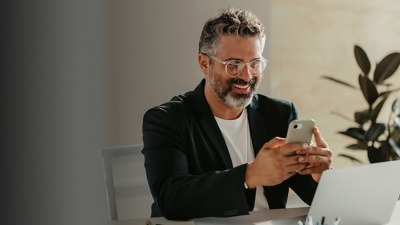 Man smiling looking at phone in office