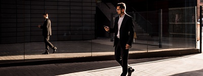 man in suit walking downtown on phone