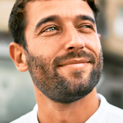 Man outside smirking and looking up