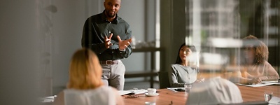 Man presenting to group of colleagues at table