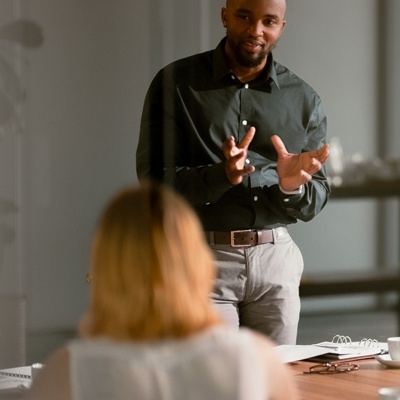 Man presenting to group of colleagues at table