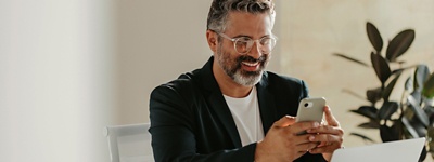 Man smiling looking at phone in office