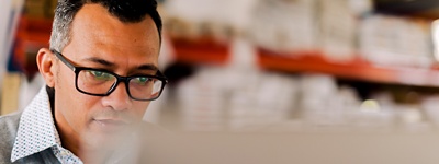 Un uomo con gli occhiali guarda lo schermo di un computer.