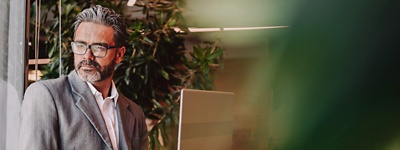 Man with glasses looking to side next to window